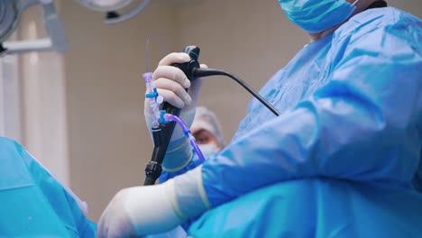 Specialist provides laparoscopic surgery. Surgical operation of the abdomen with new medical equipment. Close-up instrument in doctor's hands. New technologies in medicine.