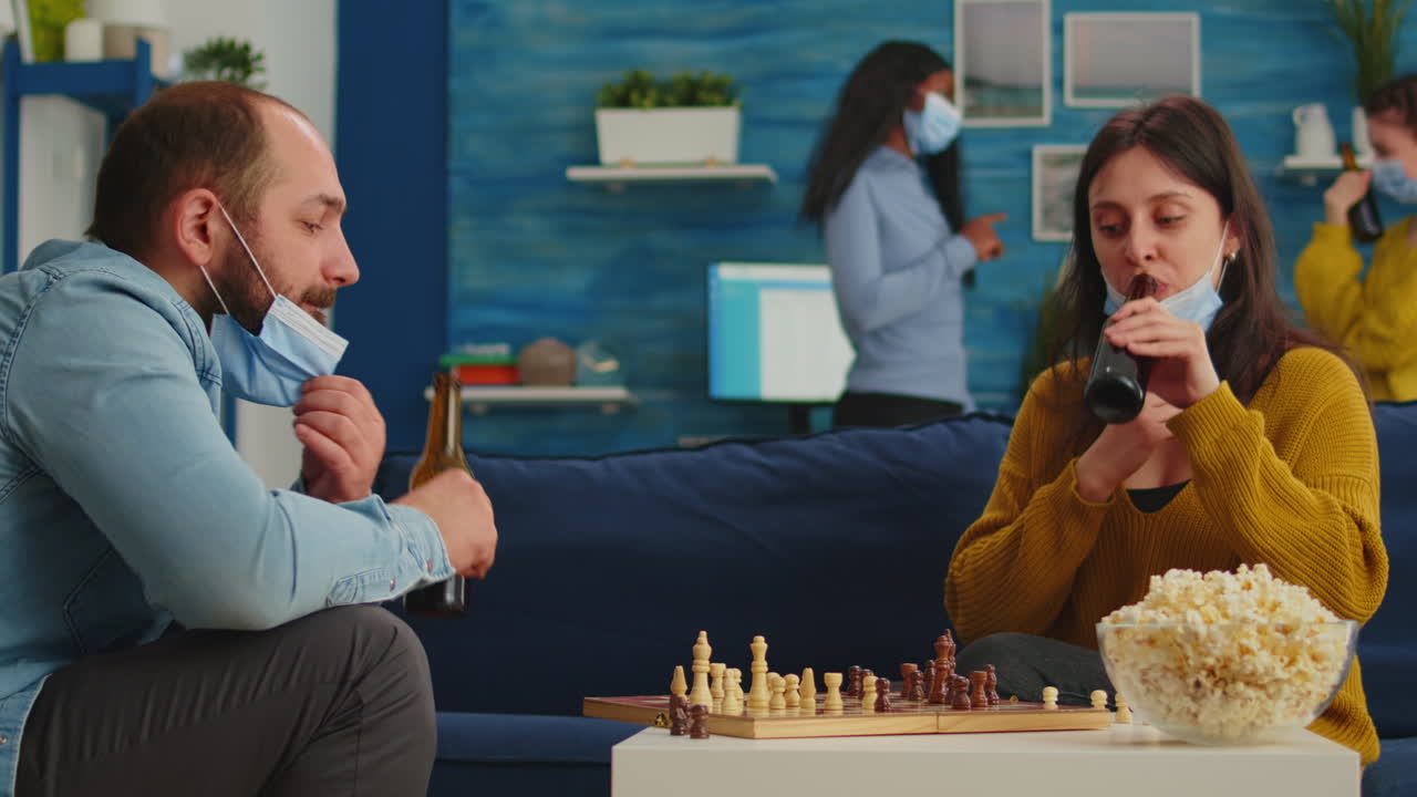 Group of friends with protection masks playing chess