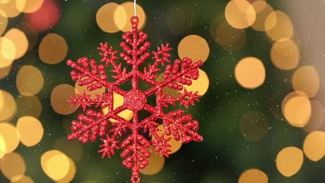 Animation-of-snow-falling-over-red-christmas-bauble-decoration