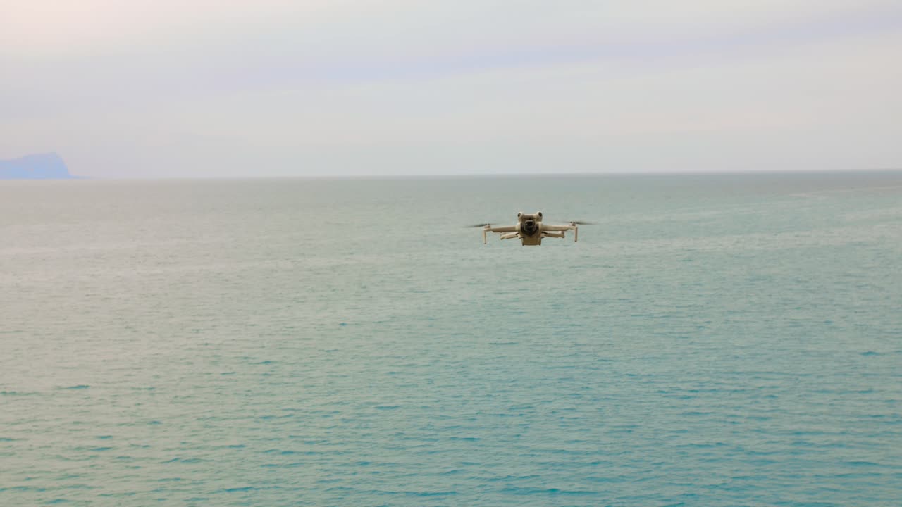 A drone navigates gracefully over calm waters, showcasing the stunning contrast between technology and the natural landscape. The tranquil setting invites a sense of peace.