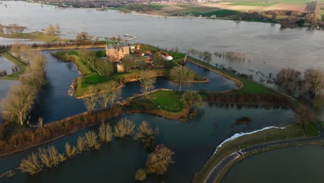 Tief-Ansteigende-Luftaufnahme-Des-Historischen-Slot-Loevestein-In-Der-Nähe-Von-Gorinchem,-Niederlande,-Umgeben-Von-Hochwasser,-Nachdem-Heftige-Regenfälle-Anfang-2024-Dazu-Führten,-Dass-Der-Fluss-Waal-über-Die-Ufer-Trat