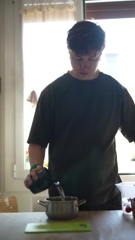 person pouring water into a pot in a kitchen