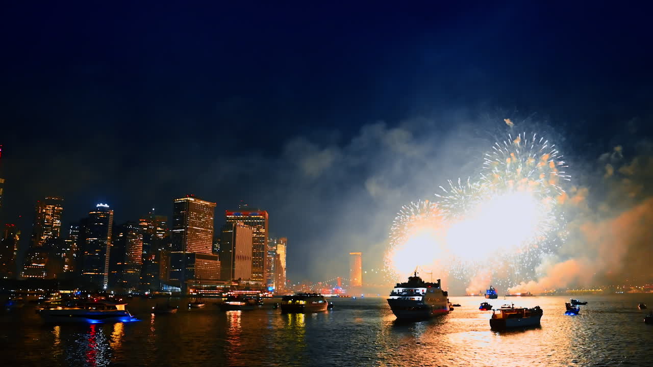 Watching spectacular fireworks in New York. Numerous boats are on the riverscape at night