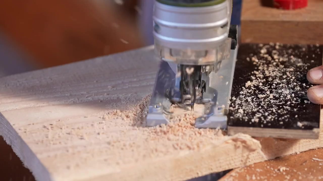 Primo piano di un seghetto alternativo che taglia una tavola di legno, creando tagli lisci e precisi. La segatura vola mentre la lama si muove attraverso il materiale, mostrando una lavorazione artigianale dettagliata