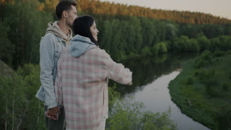 Couple enjoying a scenic view of the sunset over a river