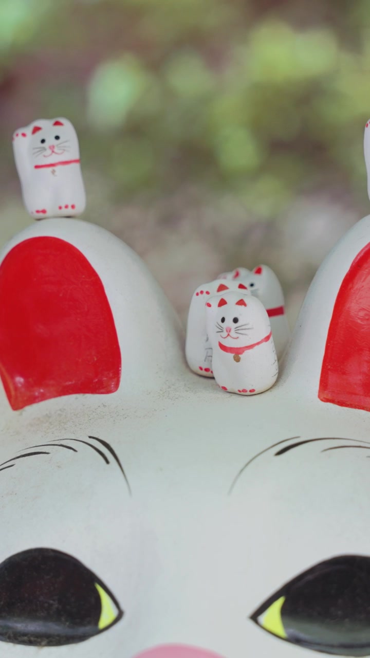 Filmagem vertical da grande estátua do gato da sorte Maneki Neko no Templo Gotokuji em Tóquio, Japão, exibindo um dos símbolos mais famosos do país de fortuna, prosperidade e cultura japonesa tradicional.
