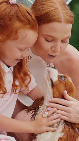 mother and daughter playing with dog