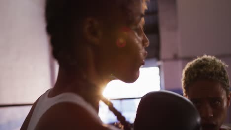 Two-mixed-race-women-training-in-boxing-ring