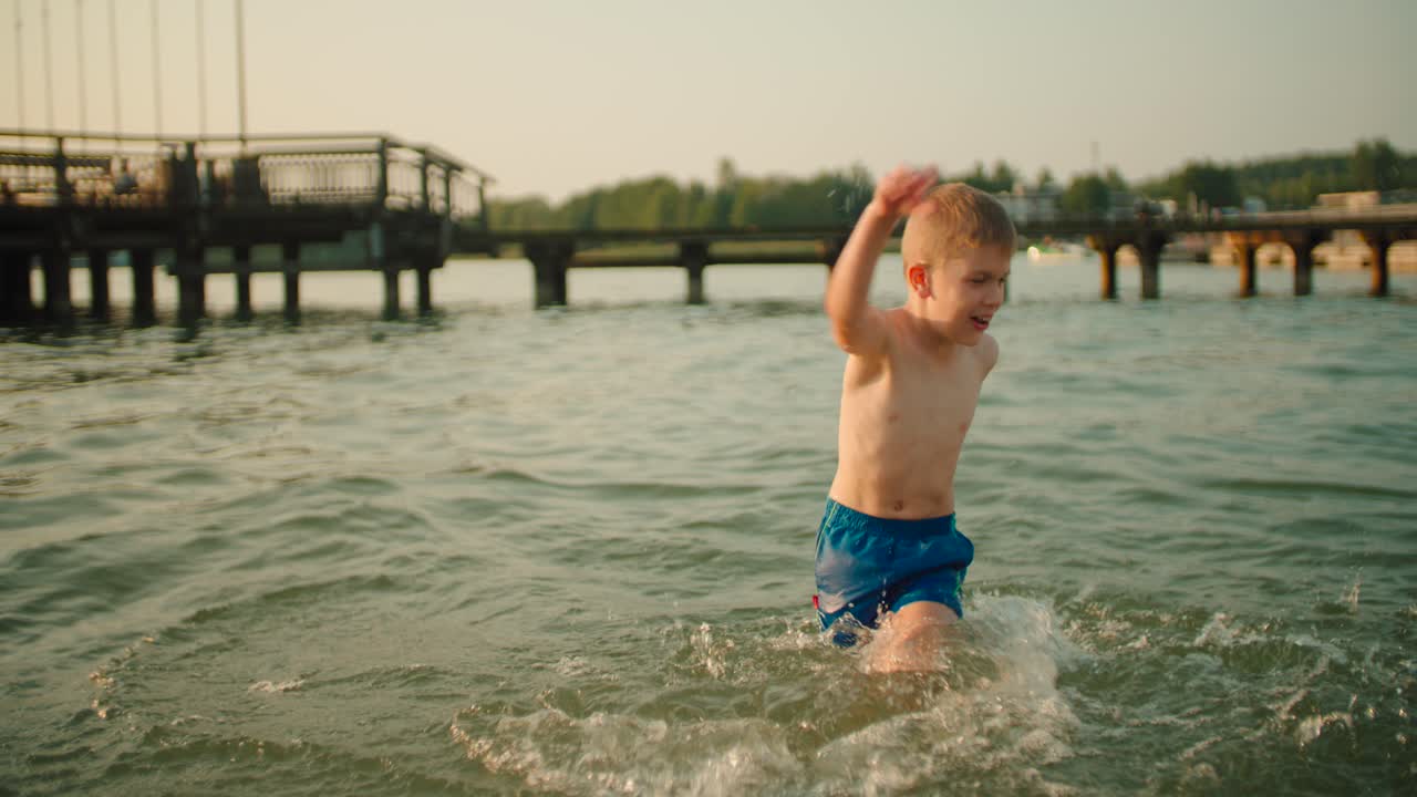 slow-mo: 작은 아이가 카메라를 향해 물을 튀기고 있습니다.