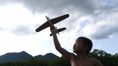 boy playing with a paper airplane