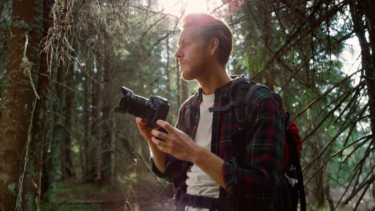 fotógrafo con cámara de fotos de pie en el bosque. excursionista tomando fotos en la cámara