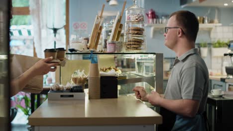 caucasian man with down syndrome giving take away food to a female client.