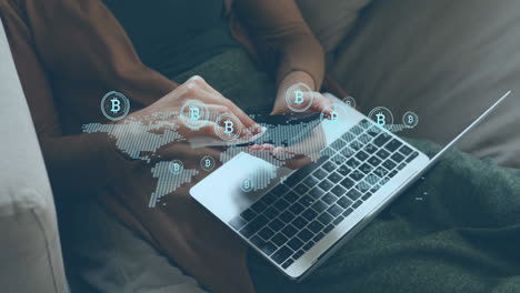 animación de iconos de bitcoin y mapa sobre la sección media de la mujer caucásica limpiando el teléfono celular con un paño