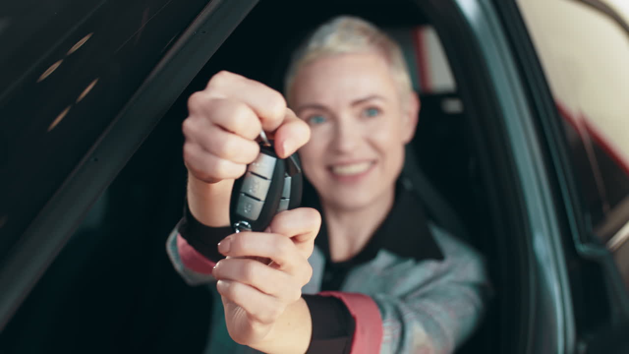 Woman holding car keys inside a car