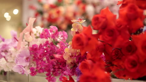 flower arrangements of red roses and orchids, panning shot
