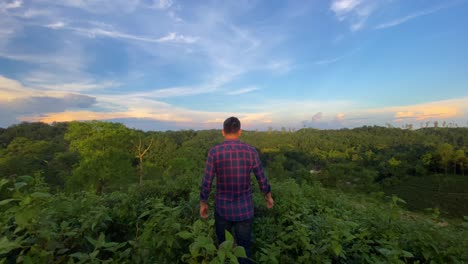 Joven-Disfrutando-De-La-Naturaleza-Sobre-La-Cima-De-La-Colina-Por-La-Mañana-Con-Un-Cielo-Dramático