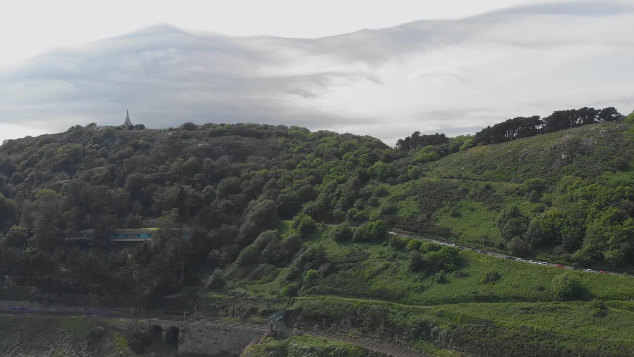 toma aérea hacia el mar que muestra la colina kiliney y la hermosa montaña verde