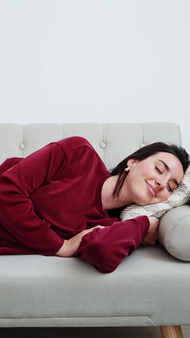 Relaxed Young Woman Napping Peacefully on a Couch