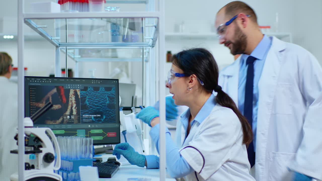Research scientists working on computer with medical equipment