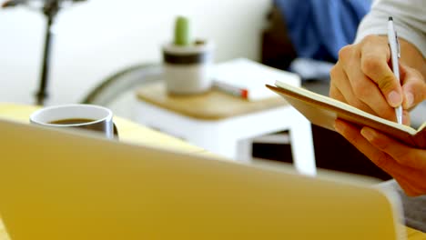 man writing on a diary in living room at home 4k
