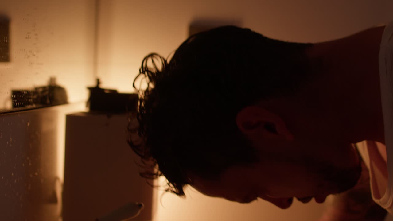 남자 가 화장실 에서 얼굴 을 고 있다