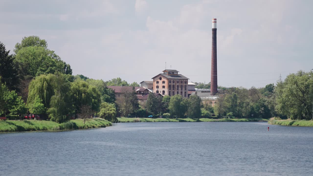 Industrial Building with a Tall Chimney by a River