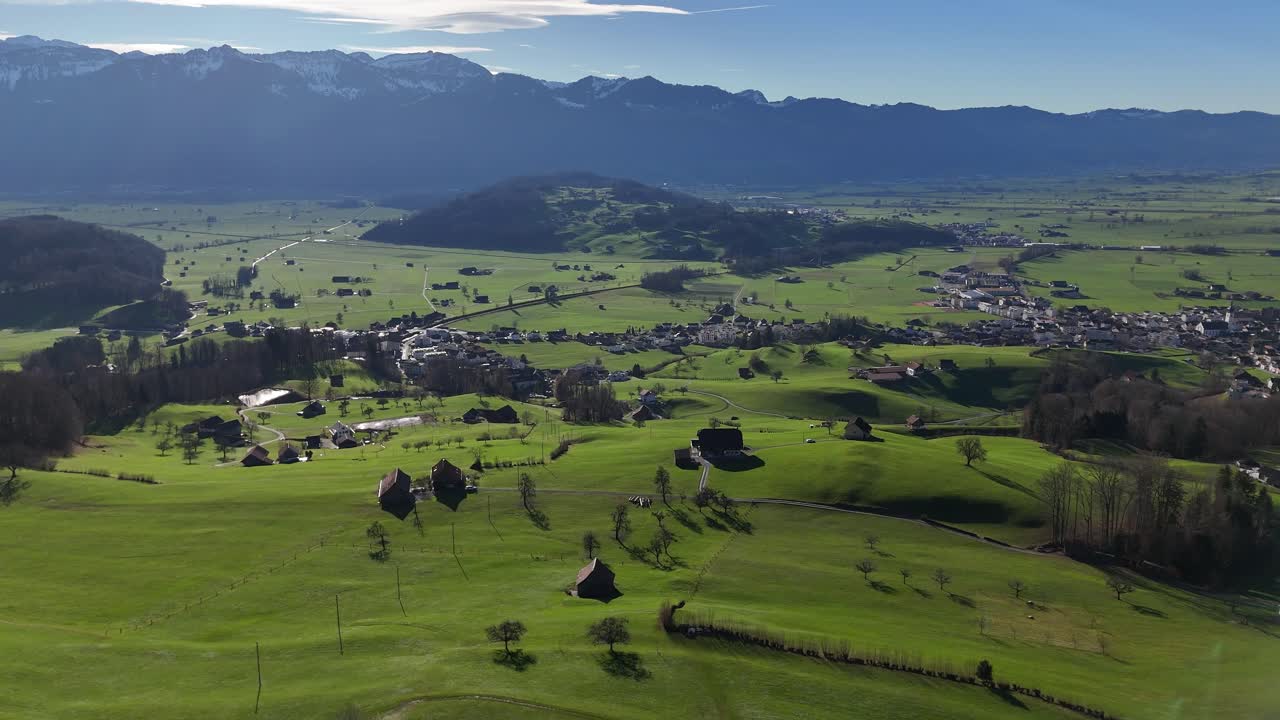 foto aérea de un pequeño pueblo en los alpes suizos con fondo montañoso - rieden, suiza