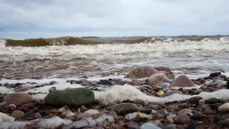 Schaumig-Brechende-Meeresbrandung-Kieselstrand-Küstenlinie-Flut-Beruhigende-Bunte-Steine-Rechts-Dolly-Aufnahme