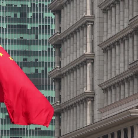 the chinese flag flies in a business district in shanghai china