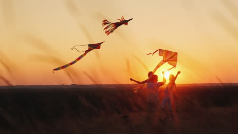 Activa-Mujer-De-Mediana-Edad-Sana-Juega-Con-Dos-Cometas-De-Niños-En-El-Concepto-De-Vacaciones-De-Verano-Al-Atardecer