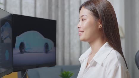 close up of asian female automotive designer crossing her arms and smiling to camera while working on 3d model of ev car on the desktop computers in the studio