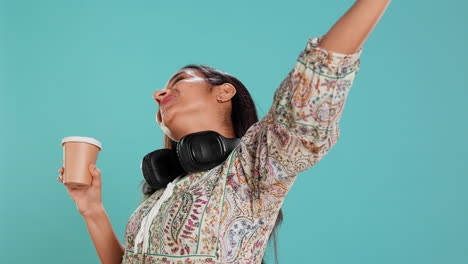 Joyful-woman-stretching-and-sipping-coffee-after-waking-up