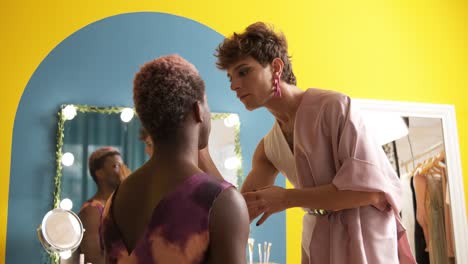 two transgender men making up in a colorful dressing room