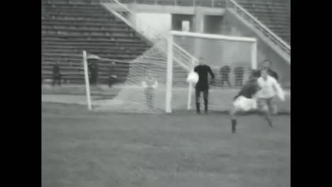 man kicking soccer ball on field, active athlete engaged in sports activity. circa ussr 1970: a man is seen energetically kicking a soccer ball on top of a field.
