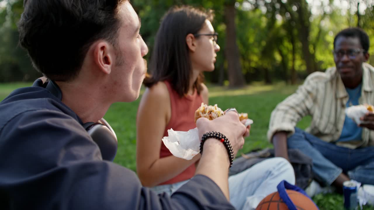 친구 들 이 공원 에서 점심 을 즐기고 있다