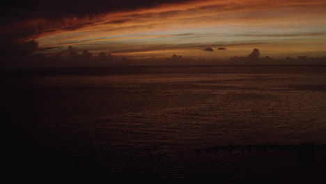 luxury travel and romantic vacation theme - crane type aerial reveal from behind silhouetted palm tress over ostiones beach in puerto rico at sunset