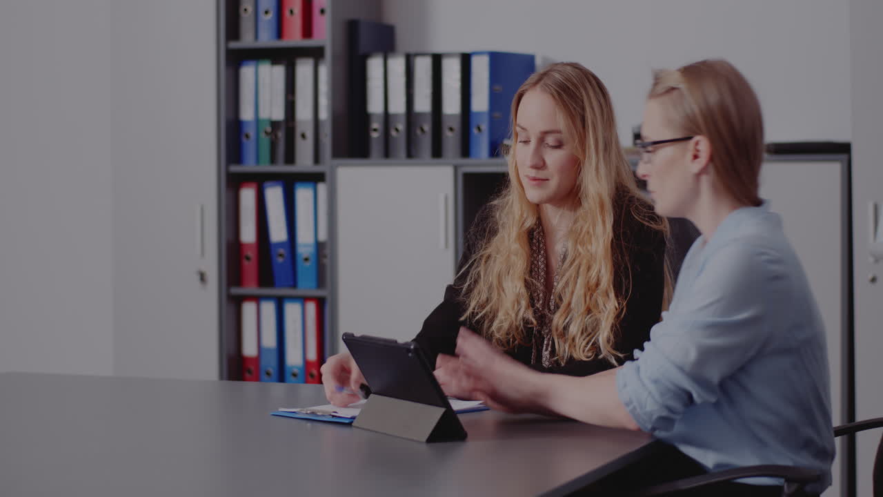 Two women in a business meeting looking at a tablet
