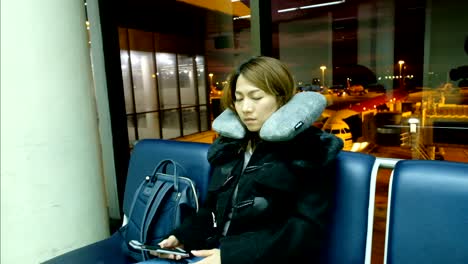 4k slow motion: a asian woman fell asleep on chair at international airport terminal. passengers of transfer flight waiting for boarding