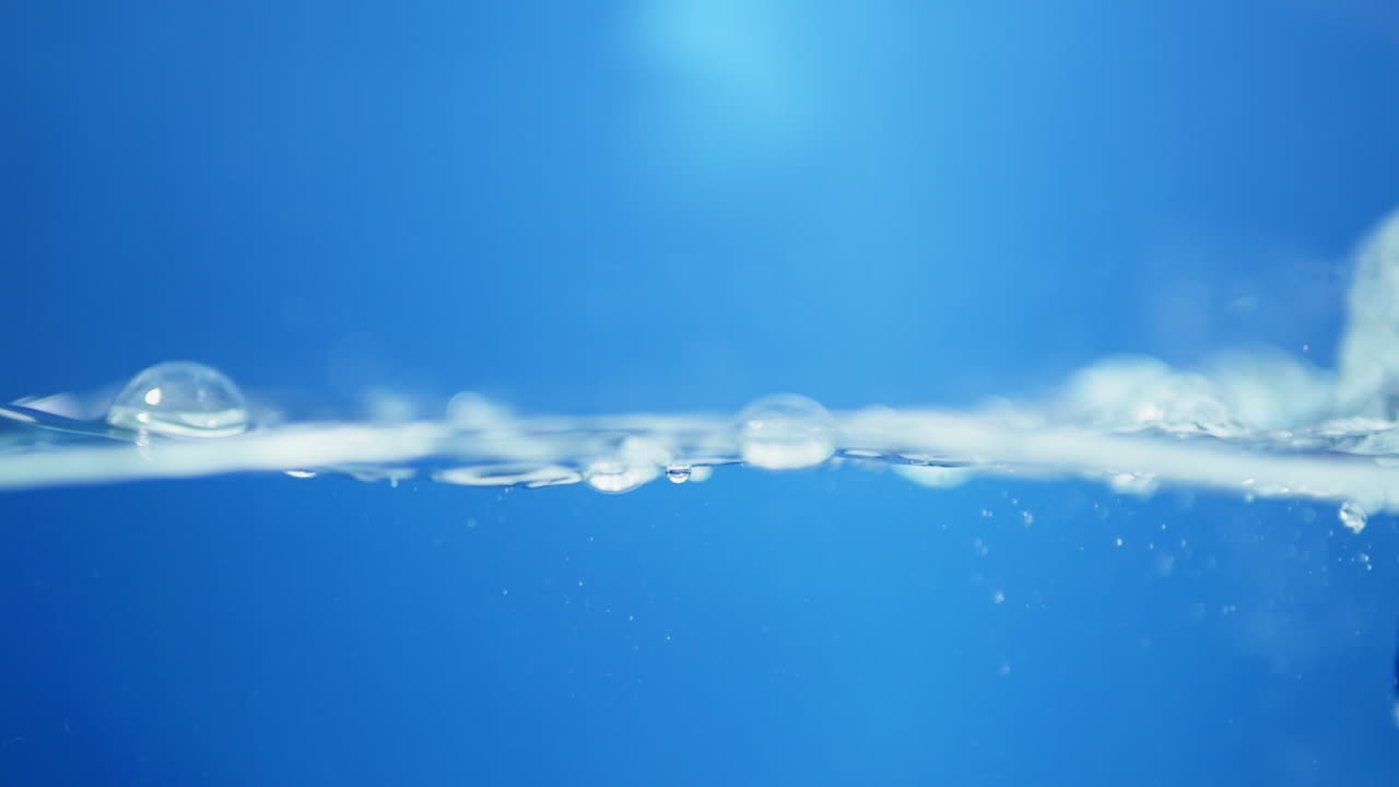 Elegant slow-motion portrayal of blue water waves, highlighting the pure essence of drinking water and its refreshing qualities.