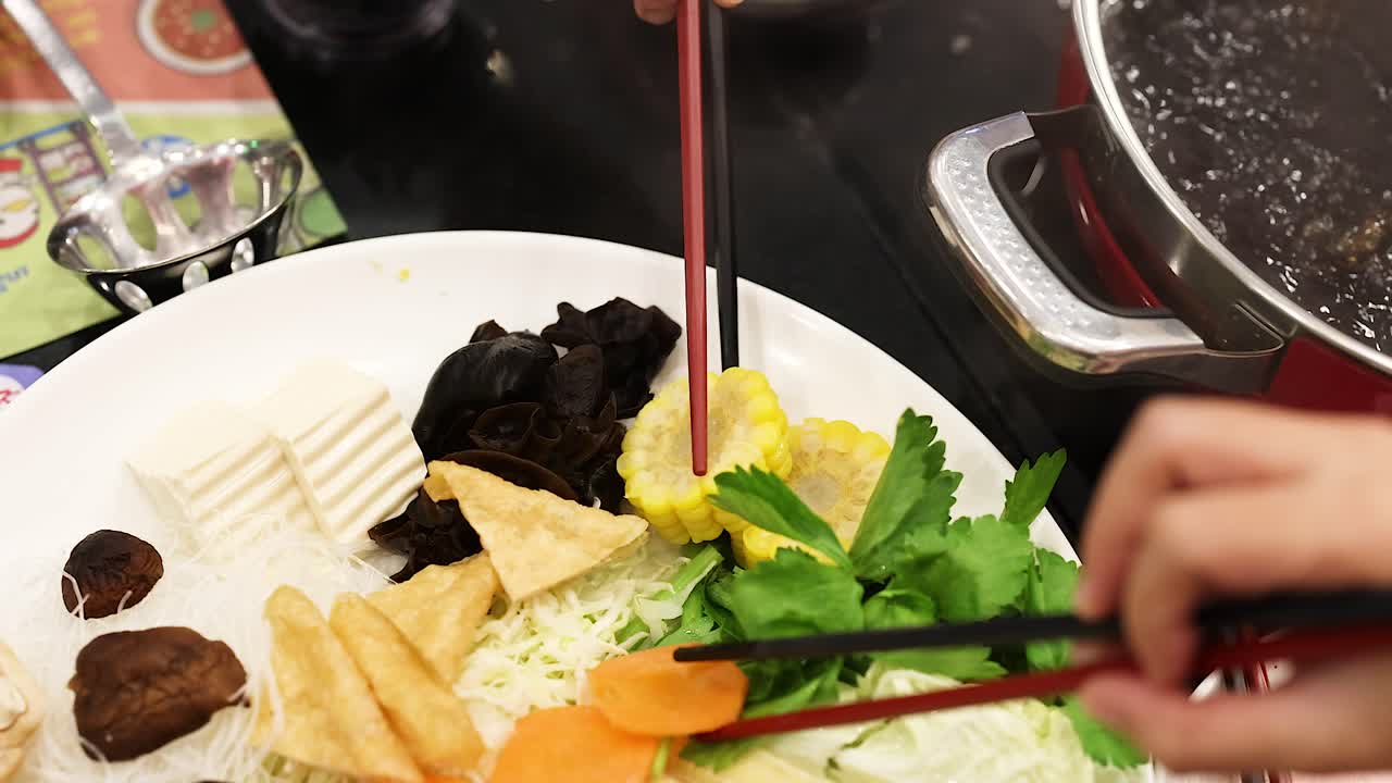 가락으로 뜨거운 비에 재료를 조리하는 것