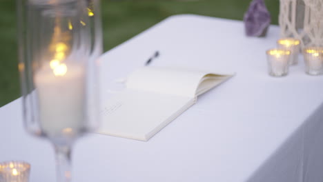 wedding book rests on table at dusk for guest to write wish to newlyweds