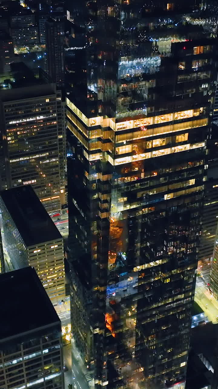 Skyscraper with large glass windows facades and lights. Establishing Aerial View Shot of Philadelphia at night evening, Pennsylvania USA. Vertical video