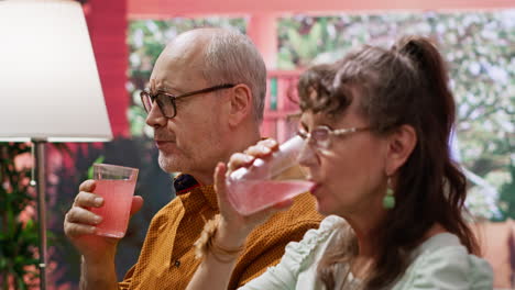 senior man and woman drinking fizzy effervescent vitamins with glasses of water