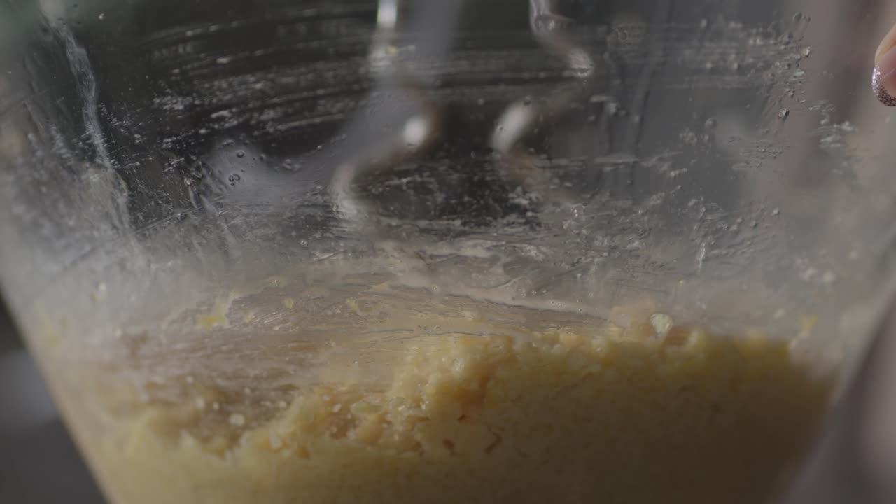 Primo piano di un impasto crudo che riposa all'interno di una ciotola di vetro trasparente