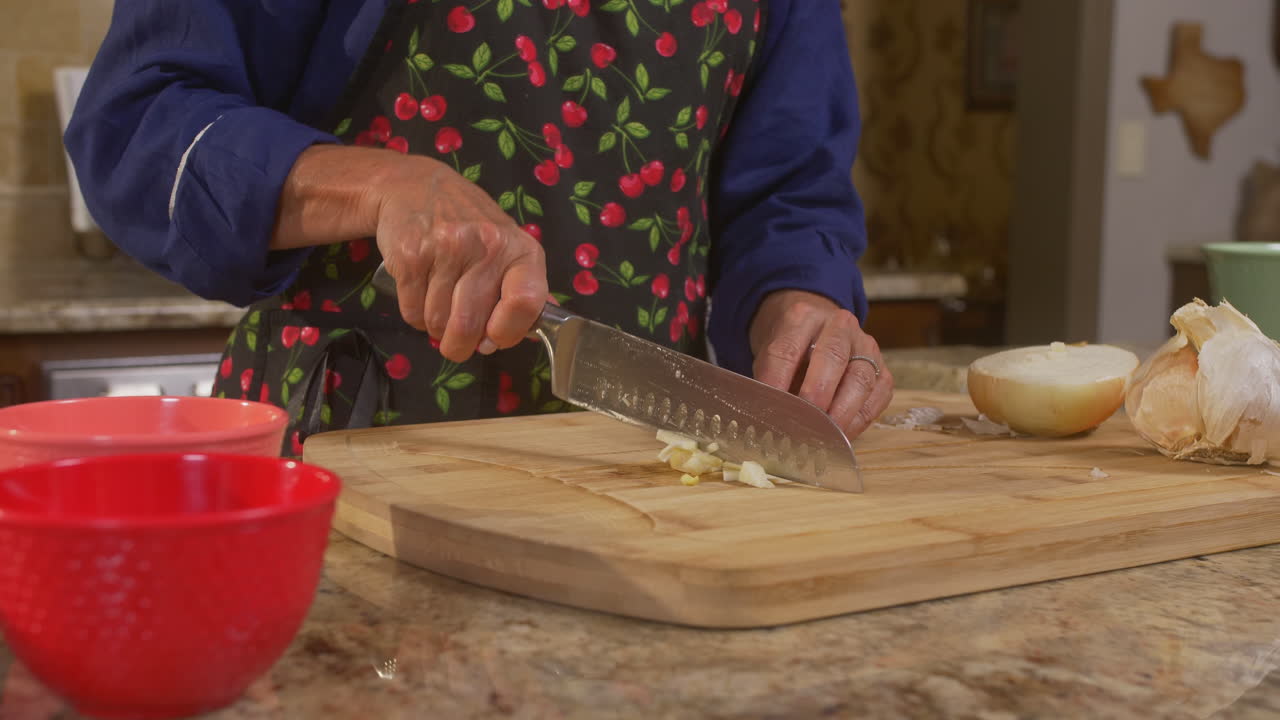 Woman's chopping vegetables on a cutting board to prepare for cooking