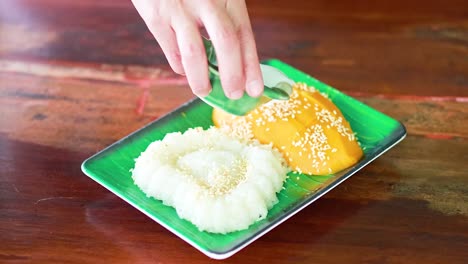 pouring coconut milk over mango sticky rice