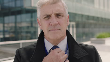 portrait of confident mature businessman ceo getting ready for corporate meeting looking serious in urban city office building background