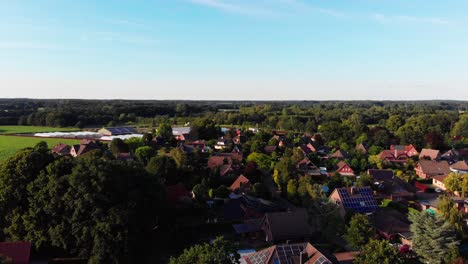 Una-Toma-Aérea-De-Drones-Volando-Sobre-Un-Bonito-Pueblo-Bajo-Un-Cielo-Azul-Claro