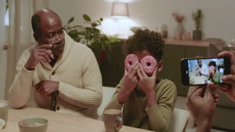 black men and boy having fun while eating at home