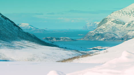 Medium-long-lens-shot-down-a-valley-towards-Tromvik,-Norway